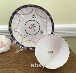 Bol à thé et soucoupe en porcelaine de la Couronne Derby antique de 1778, peints à la main avec des motifs floraux et une bordure en cobalt.