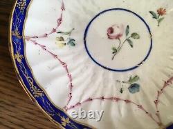 Bol à thé et soucoupe en porcelaine de la Couronne Derby antique de 1778, peints à la main avec des motifs floraux et une bordure en cobalt.