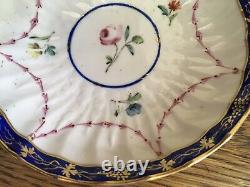 Bol à thé et soucoupe en porcelaine de la Couronne Derby antique de 1778, peints à la main avec des motifs floraux et une bordure en cobalt.