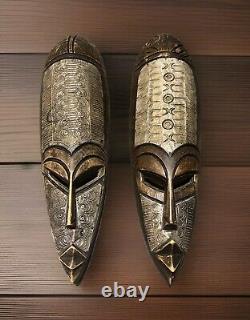 Ensemble de deux masques en bois sculptés à la main de la Côte d'Ivoire, pour décoration murale.